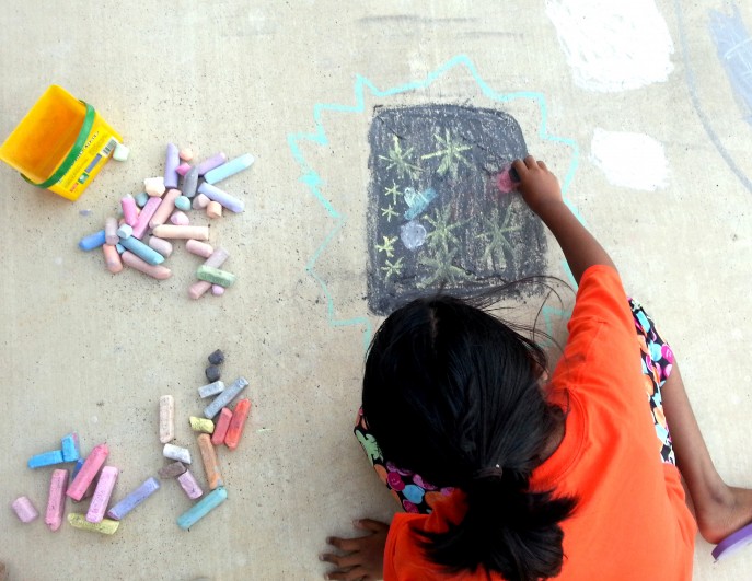 Child drawing with sidewalk chalk