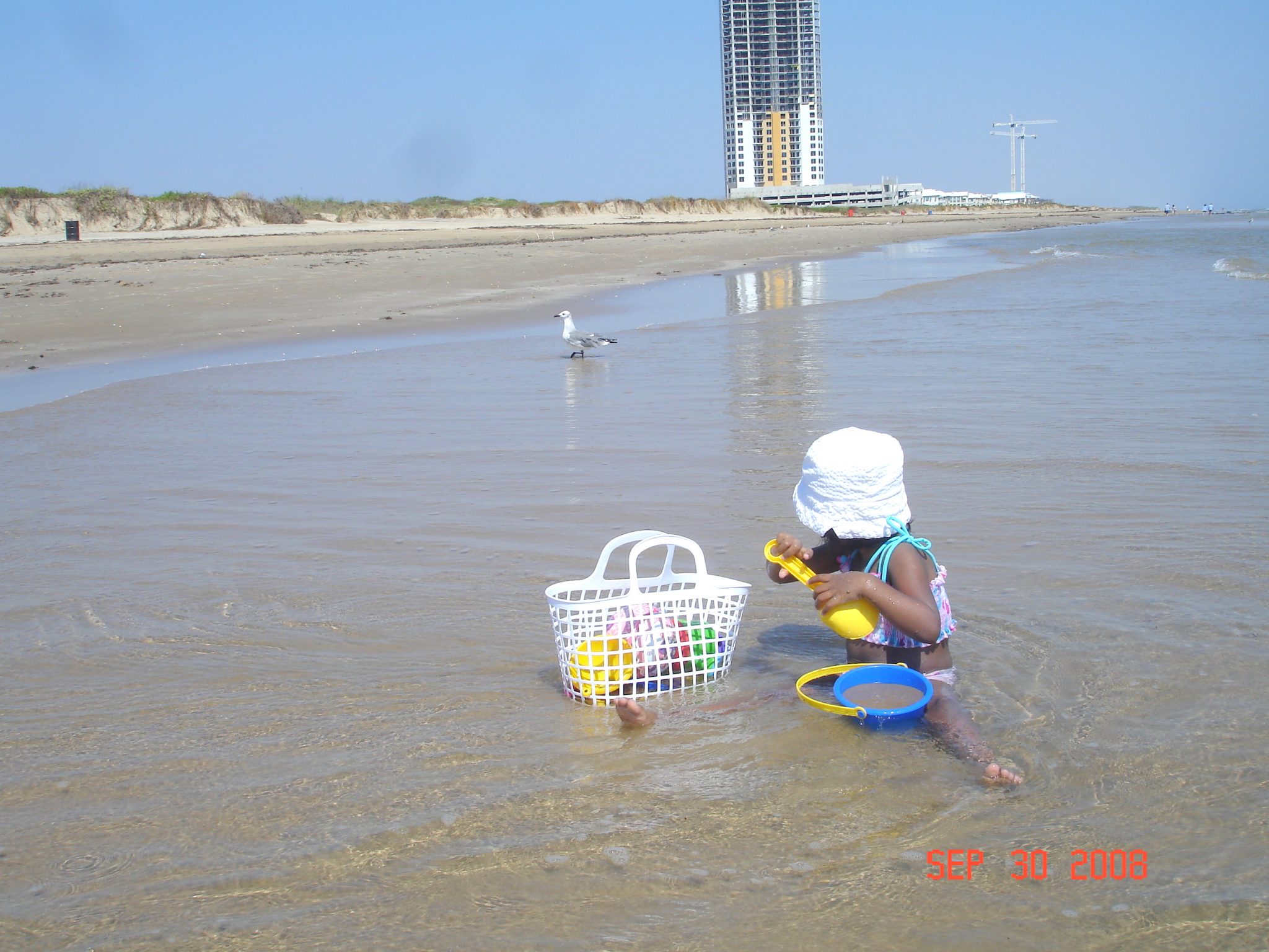 little girl sitting on the beach shore- South Padre Island, Texas