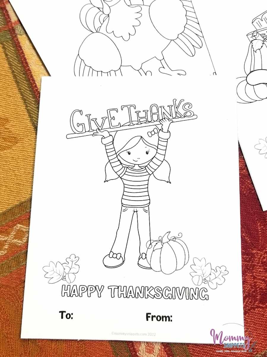 Little girl holding up a Give Thanks sign -featured on a Thanksgiving coloring card.